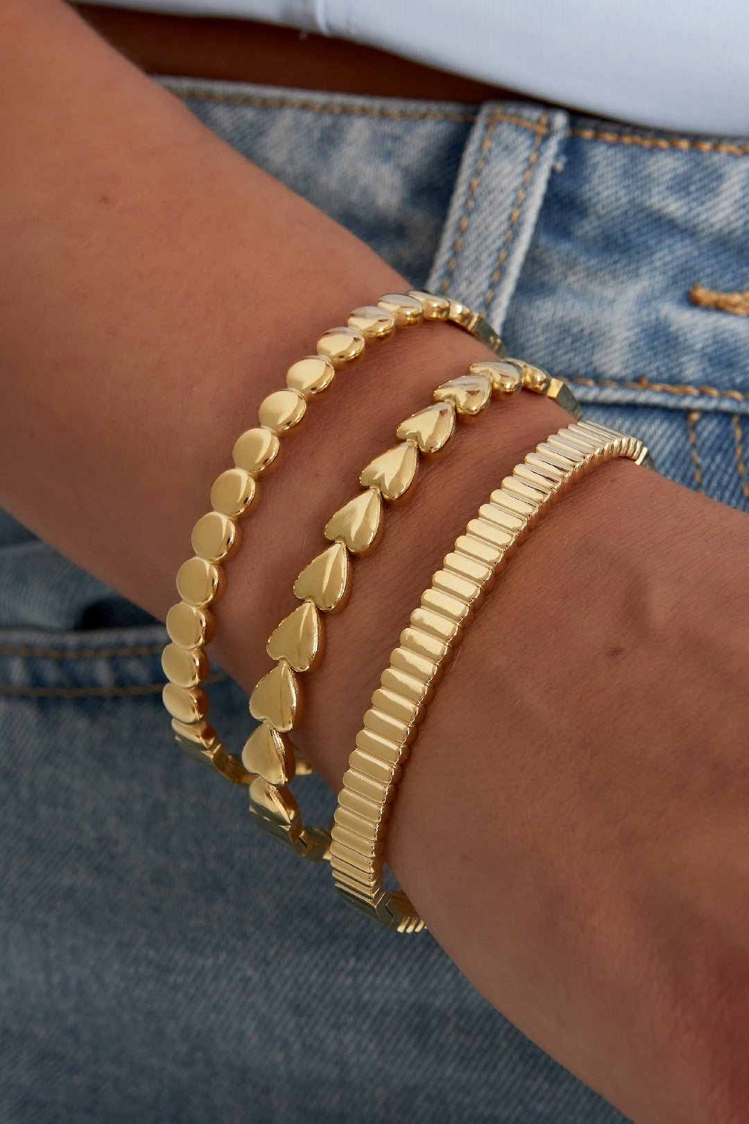 Bangle armband met hartjes in het goud om pols
