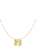 Ketting met parels en stipjes en een hanger van strik in het goud