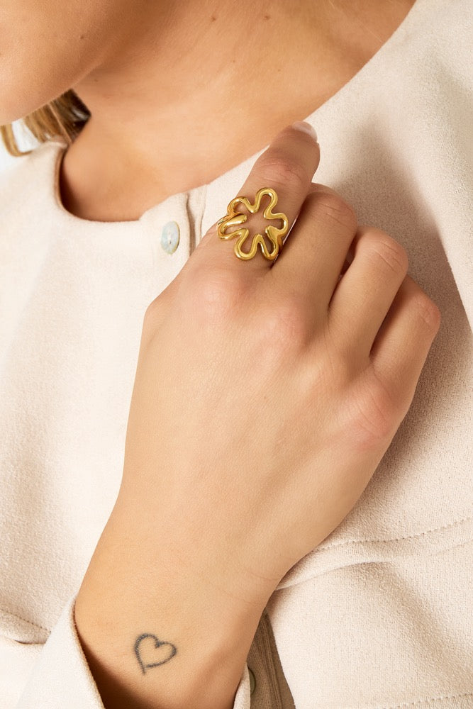 Ring met grote bloem in het goud om vinger