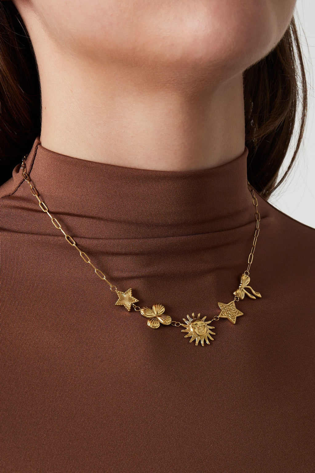 Statement ketting met verschillende figuurtjes van bloem, zon, ster en strik in het goud